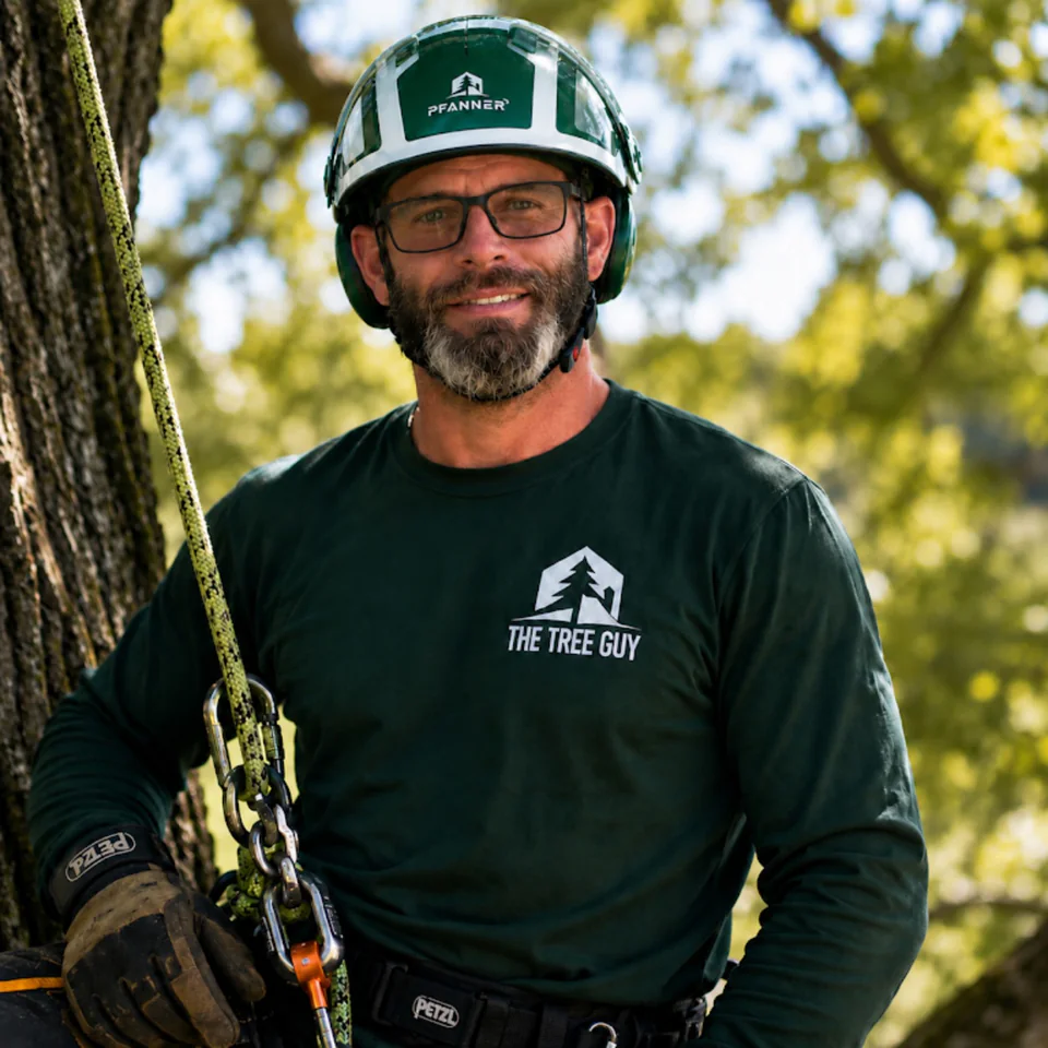Garret Smith, owner of The Tree Guy, wearing his company shirt and climbing helmet
